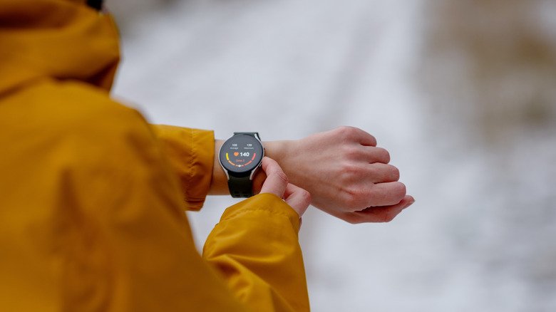 Close-up of an athlete checking heart rate on a smartwatch during a winter workout