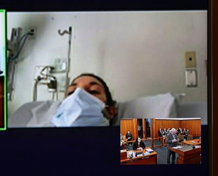 A woman in a mask and in a hospital bed appears before court (inset) via video.