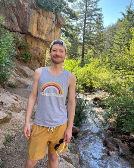 Jason Wood on a hiking trail with rocks and trees in the background