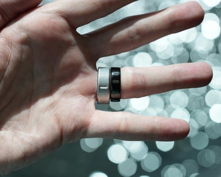 The Oura Ring 5 in black next to the Ring 4 in brushed silver.