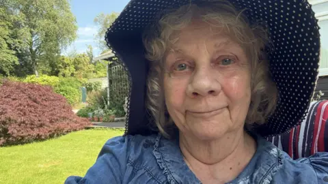 Fiona Cameron A selfie of a woman in a garden wearing a wide-brimmed hat.