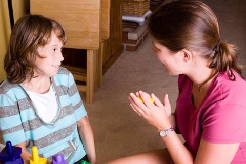 Autistic girl getting praise during therapy.