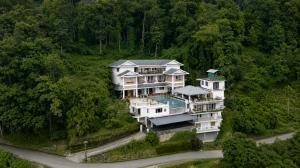 a photo of a luxury rehab centre for deaddiction and mental health issues, situated in the eastern himalayas, surrounded by lots of tall trees