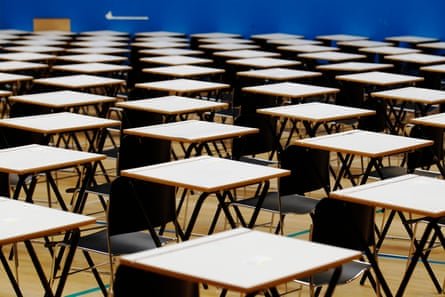 Tables and chairs are lined up in a school hall in preparation for the start of a GCSE mathematics exam