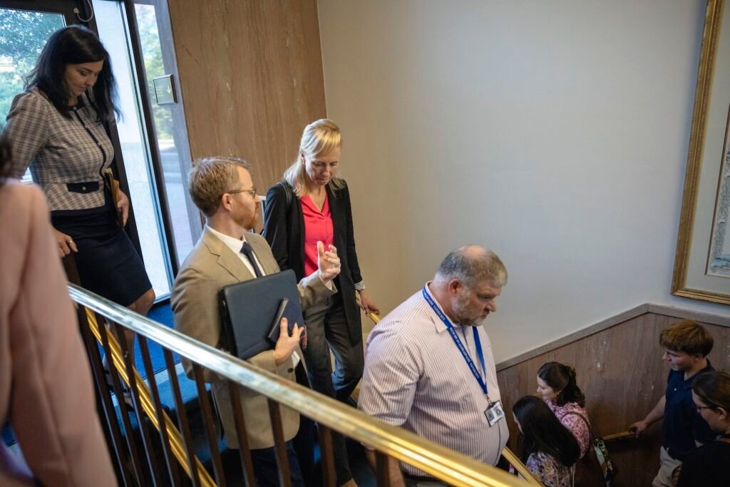 Benjamin Clapper, executive director of Louisiana Right to Life, speaks with state Surgeon General Dr. Evelyn Griffin as they walk down a staircase at the State Capitol