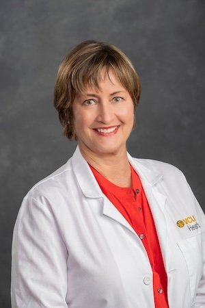 Nurse Krebs wears a red shirt under her white medical coat