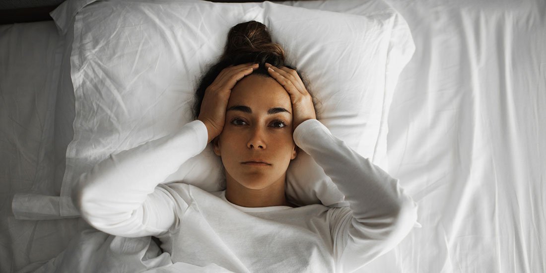 Woman in bed, frustrated because she can't sleep