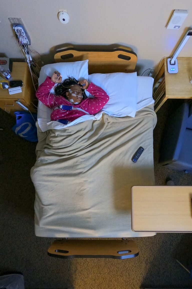 Overhead view of a patient lying still on her back in the early stages of sleep.