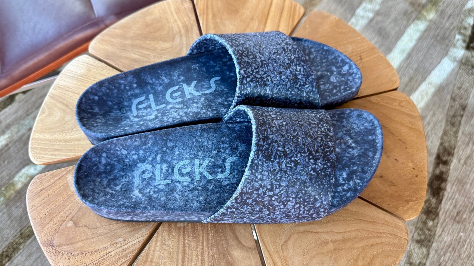 Fleck East Beach Slide sandals in blue on a side table