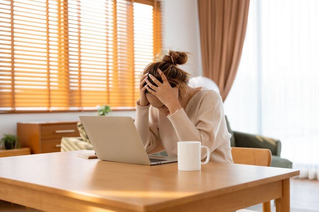 woman suffering stress at table with laptop computer