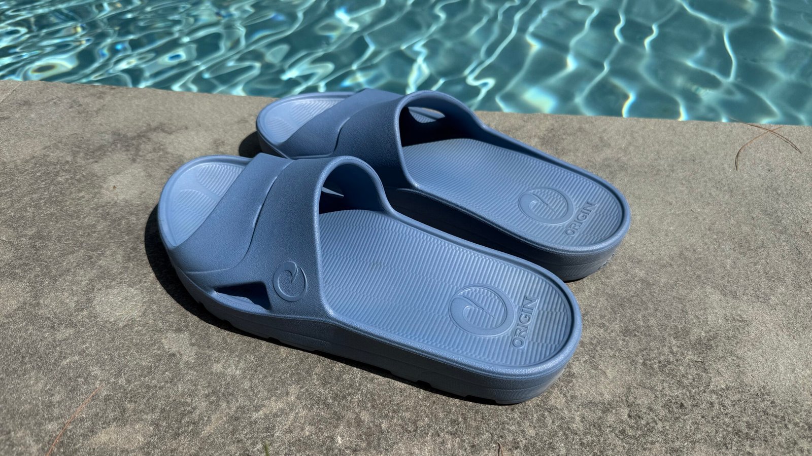 Among the best recovery slides of 2026, the Origin RTX Slide is shown sitting on the side of a pool