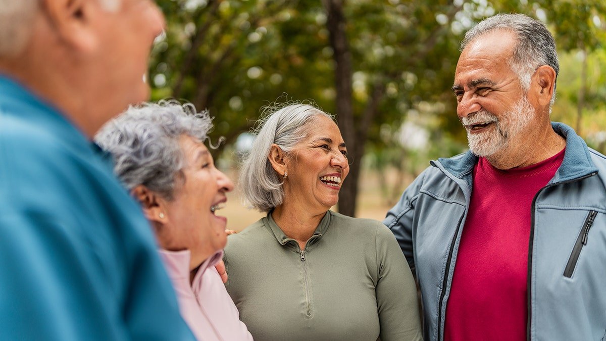 four senior friends talk and laugh