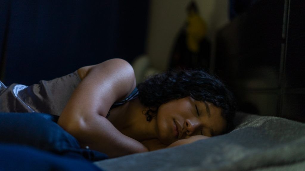 Latinx person pictured asleep in bed