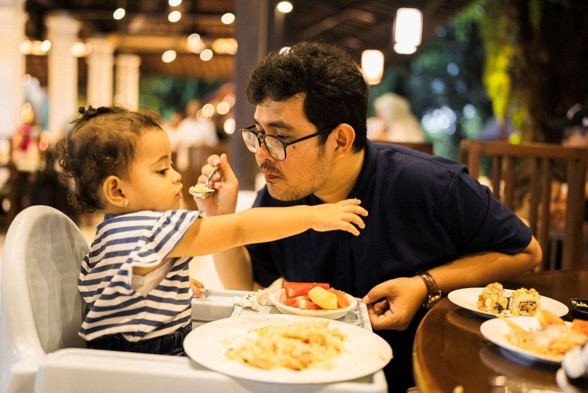 Father feeding his child in a restaurant