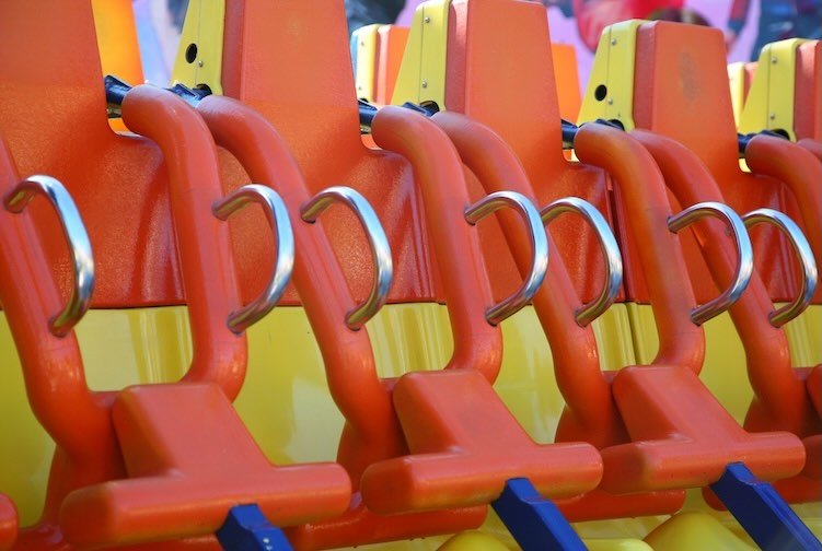 orange and yellow seats of a roller coaster at the fair
