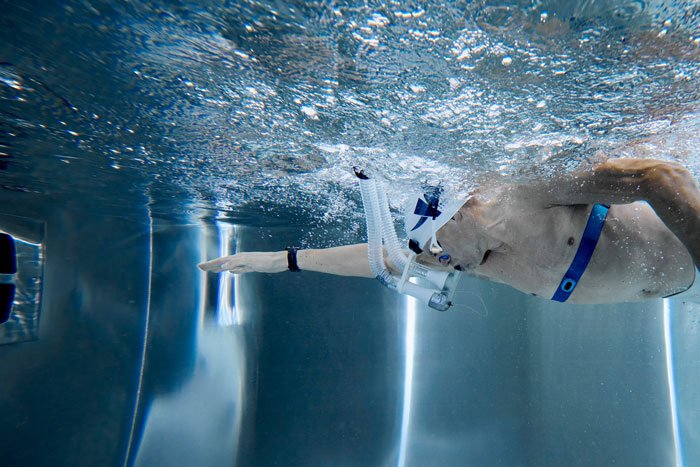 Swimmer underwater wearing a fitness tracker designed for active health monitoring.