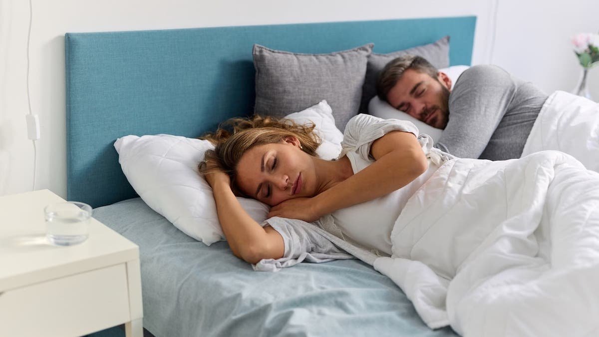 Couple sleeping peacefully in bed at home.