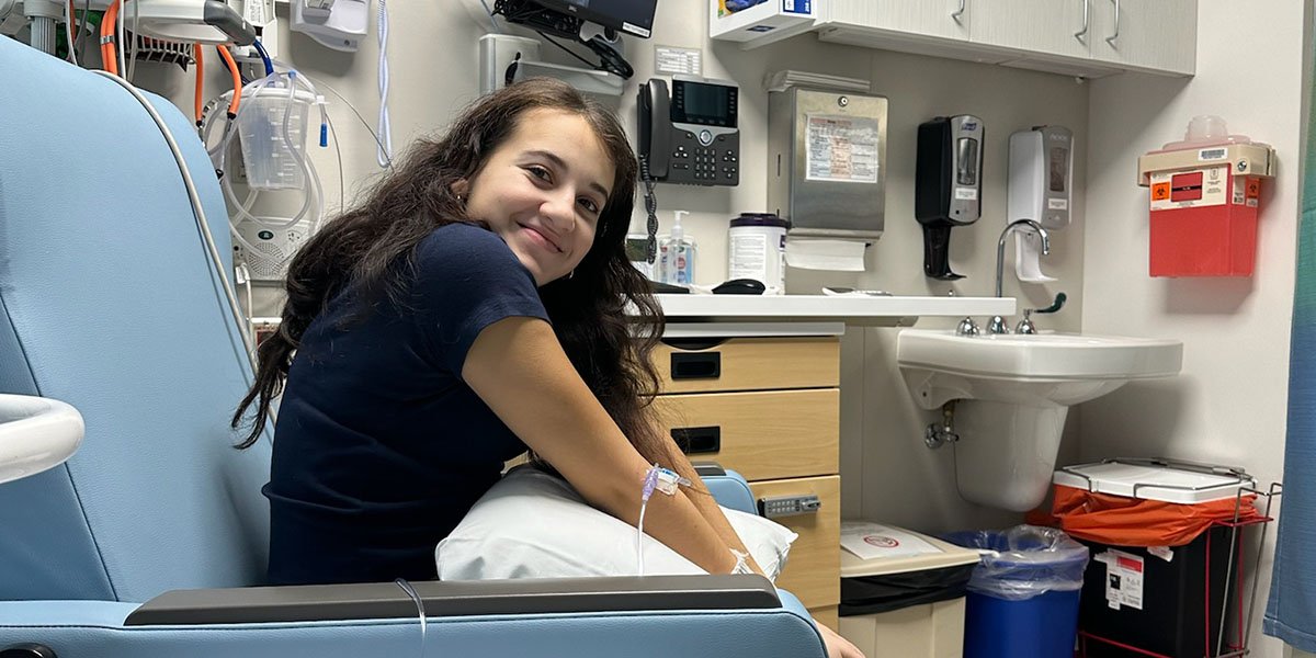 A girl sits in a hospital chair