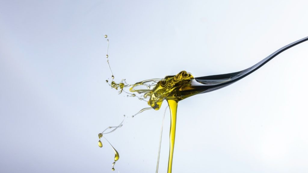A close up of a tablespoon of olive oil