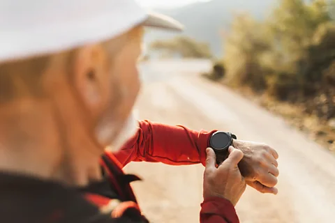 Getty Images A man checks his smartwatch while out on a run (Credit: Getty Images)