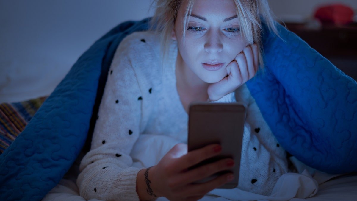 woman on phone in bed